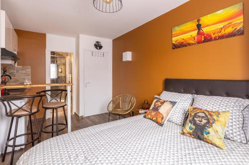 a bedroom with a bed and a kitchen with a bar at Appartements proche Paris Disney in Torcy