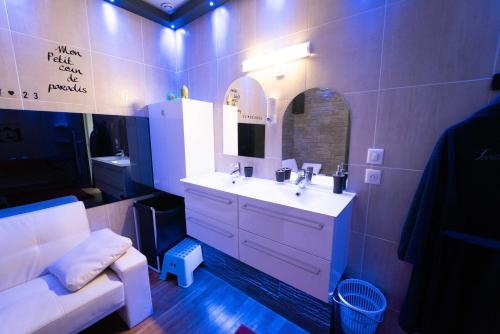 baño con lavabo, espejo y sofá en Lovelove23spas, en Villeurbanne
