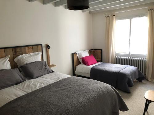 a bedroom with two beds and a window at Gîte des Cailloteux in Couffy