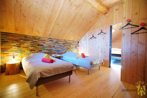 シャンボン・シュル・ラックにあるGrande Cabane du Lacのレンガの壁、ベッド2台が備わるベッドルーム1室が備わります。