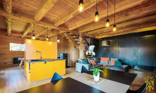 un salon avec une table et une armoire jaune dans l'établissement Grande Cabane du Lac, à Chambon-sur-Lac