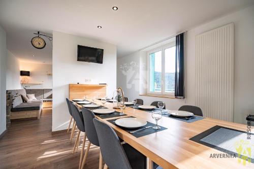 une salle à manger avec une longue table et des chaises dans l'établissement Mouteroun 3, à Chambon-sur-Lac