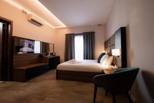 una camera d'albergo con letto e sedia di Pebbles Resort a San Pawl il-Baħar