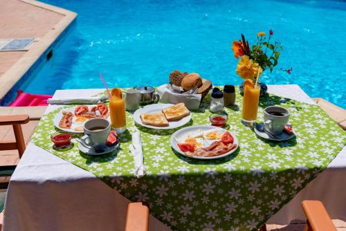 Helena Inn في سفوروناتا: طاولة عليها أطباق من المواد الغذائية والمشروبات