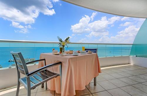 a table on a balcony with a view of the ocean at Holiday Inn Campeche, an IHG Hotel in Campeche