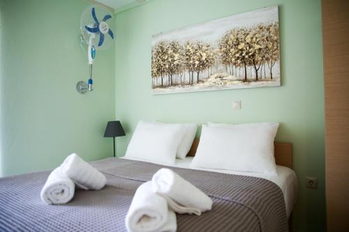 een slaapkamer met 2 bedden en handdoeken bij Green Apartment in Leptokaria in Leptokarya