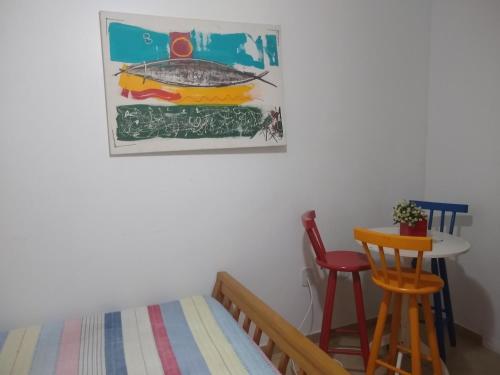 a bedroom with a bed and a table and chairs at Hostel casa amarela in Rio das Ostras
