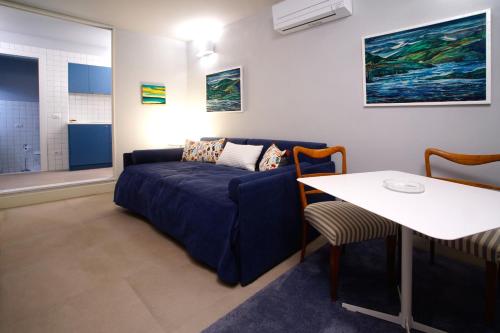 a living room with a blue couch and a table at Casa Sironi in Tortona