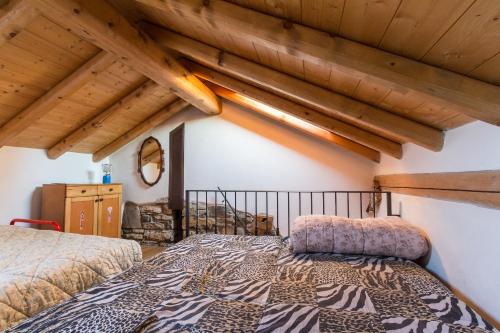 una camera con letto e soffitti in legno di Le Casette di Laila a Colonno