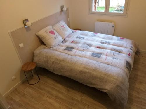 Un dormitorio con una cama con una manta encima. en Location A.M.I, en Bellegarde-sur-Valserine