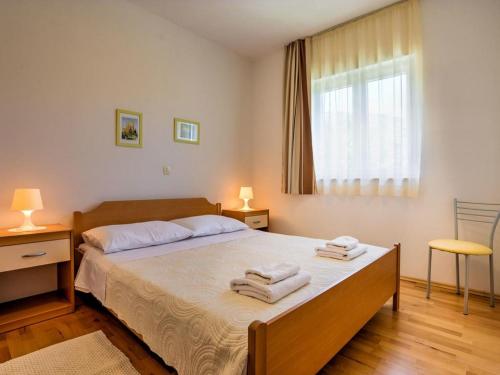 1 dormitorio con 1 cama grande y toallas. en Apartments Villa Tara, en Brseč