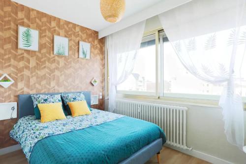 une chambre avec un lit bleu et une fenêtre dans l'établissement Appart'Confort - Le Natura, à Saint-Brieuc