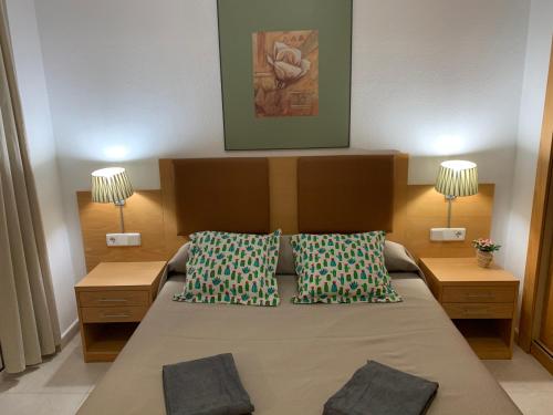 ein Schlafzimmer mit einem großen Bett mit zwei Kissen in der Unterkunft Bea Laguna Beach Vera Playa - Gratis Jacuzzi in Vera