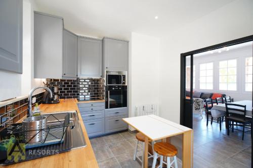 une cuisine avec des armoires blanches et une table à l'intérieur dans l'établissement Les Trembles, à Chambon-sur-Lac