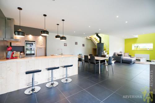 - une cuisine avec un bar et des tabourets dans la chambre dans l'établissement Villa Ballat's Dine, à Murol