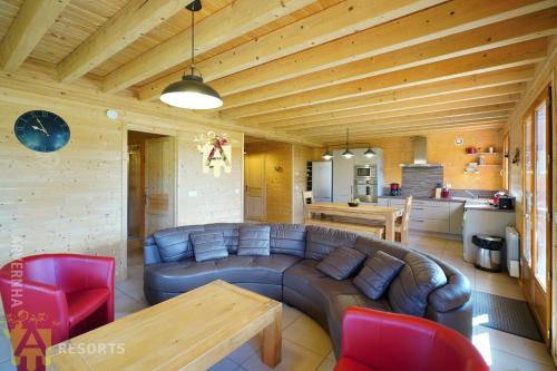 un salon avec un canapé et une table et une cuisine dans l'établissement Chalet de Solène, à Chambon-sur-Lac