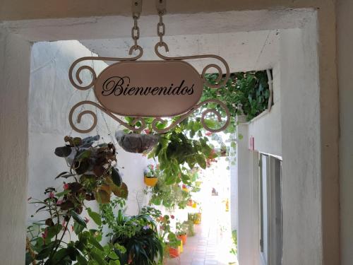 a sign hanging from the ceiling of a room with plants at Hospedaje Los Capuchinos in Socorro