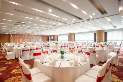 a large room with white tables and white chairs at Holiday Inn Chengdu Century City-EastTower in Chengdu