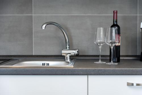 a kitchen sink with two glasses and a bottle of wine at Sunny Biokovo Apartments in Bast