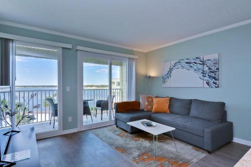 a living room with a couch and a balcony at 412-AMAZING Views, Waterfront, WIFI, Pool, Close to BUCS Stadium in Tampa