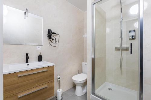 a bathroom with a shower and a toilet and a sink at Appartements proche Paris Disney in Torcy