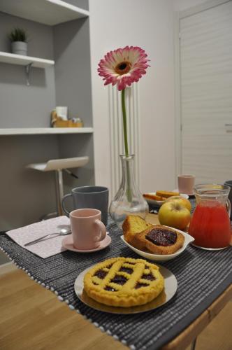 a table with food and a vase with a flower at B&B Terra di Marca in Montefortino