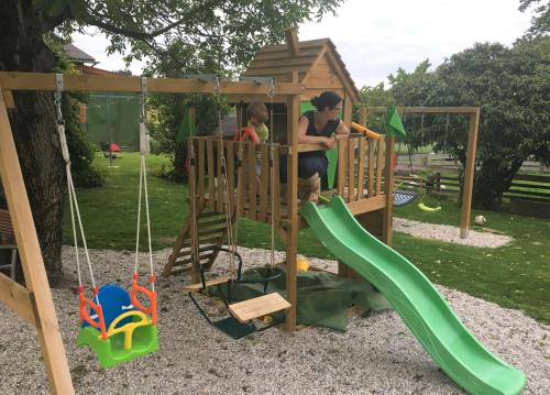 a man and a child playing on a playground at Familienbauernhof Strassbauer in Steinakirchen am Forst