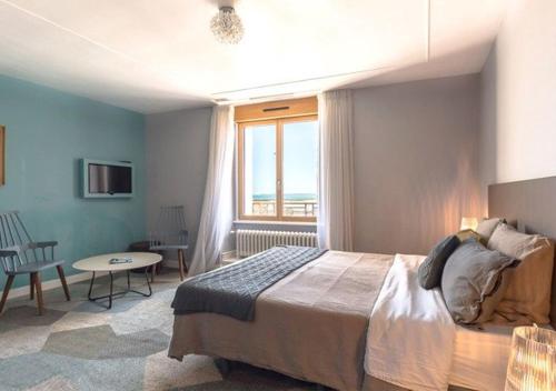 Schlafzimmer mit einem Bett, einem Tisch und einem Fenster in der Unterkunft Kêr L - Breizh & Breakfast in Cancale