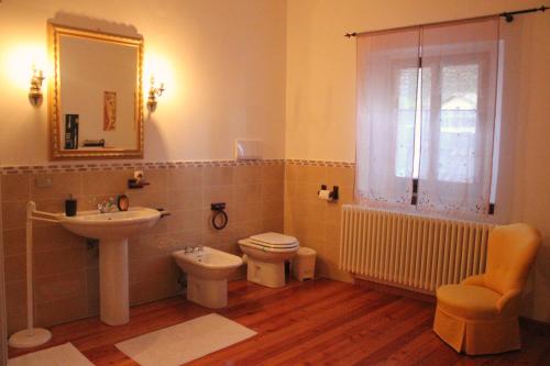 a bathroom with a sink and a toilet and a mirror at B&B Villa al Lago in Farra dʼAlpago