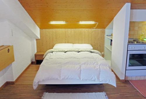 アンゼールにあるSki-in Apartment in Anzereのキッチン付きの客室の大型ベッド1台分です。