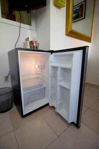 an empty refrigerator with its door open in a kitchen at Casa Zac Nicte Mx-Departamento BALAM in Cancún
