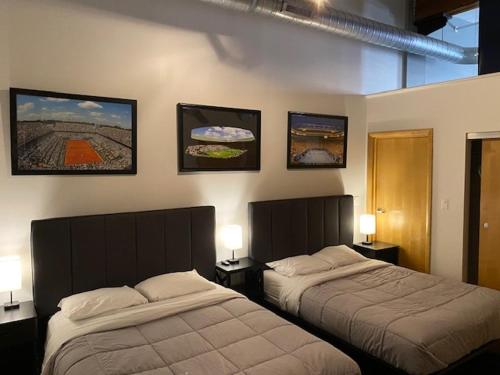 a bedroom with two beds and pictures on the wall at Modern Lofts next to Georgia St. & Convention Ctr. in Indianapolis