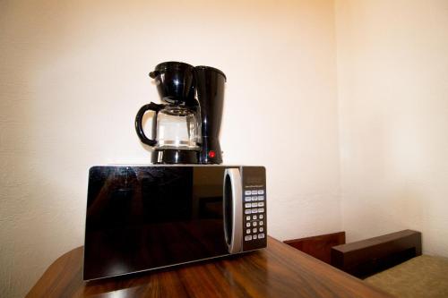 a microwave sitting on top of a wooden table at Casa Zac Nicte Mx-Departamento BALAM in Cancún