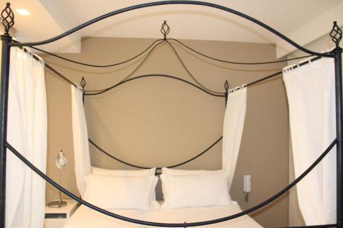 1 dormitorio con cama con dosel y almohadas blancas en Casa Plancia, en Lecce