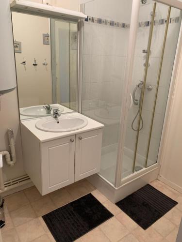 une salle de bain blanche avec une douche et un lavabo dans l'établissement APPARTEMENT FACE A LA MER 6 PERSONNES, à Cayeux-sur-Mer