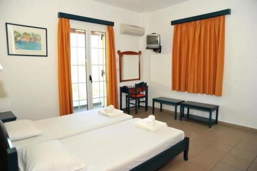 pokój hotelowy z 2 łóżkami i oknem w obiekcie Papoulias Rooms w Elafónisos