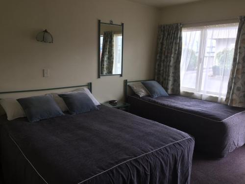a bedroom with two beds and a window at Bentons Motel in Levin