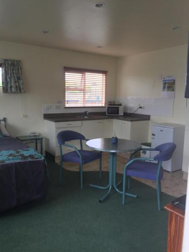 a room with a table and two chairs and a kitchen at Bentons Motel in Levin