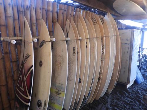 a row of surfboards lined up against a wall at Pelicano Surf Camp in La Libertad