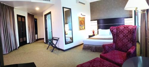 a hotel room with a bed and a chair at Good Hope Hotel in Skudai