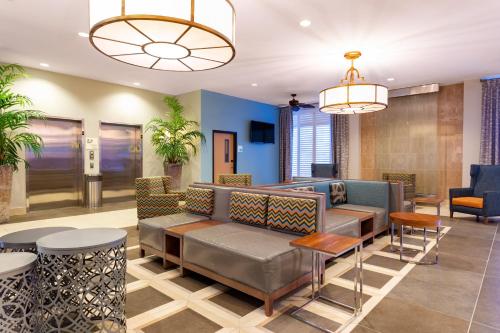 a lobby with a couch and tables and chairs at Holiday Inn Winter Haven, an IHG Hotel in Winter Haven