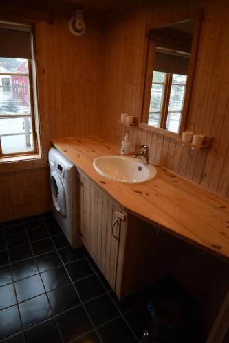 a bathroom with a sink and a washing machine at Lofoten Cabins - Sund in Sund
