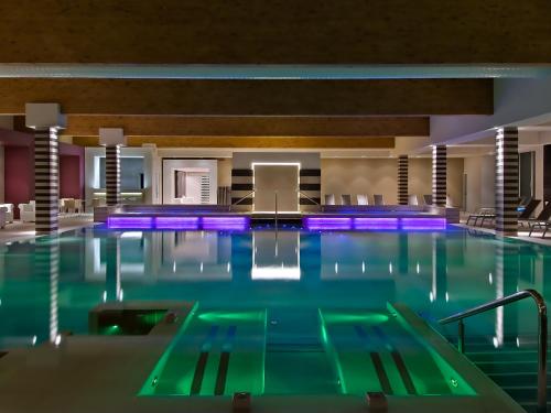 een groot zwembad met blauwe verlichting in een hotel bij Hotel Mioni Pezzato in Abano Terme
