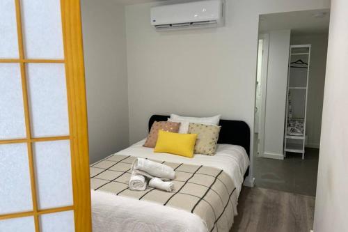 a small bedroom with a bed with a yellow pillow at 10A Brunswick Living Studio Close to APT and CBD Free Wifi Tram at Doorstep in Melbourne