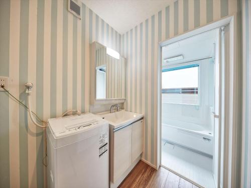 La salle de bains est pourvue d'un lavabo, d'un lave-linge et d'un sèche-linge. dans l'établissement Private Villa Espacio Onna, à Inbu