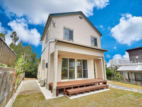 a house with a bench in front of it at Private Villa Espacio Onna in Inbu