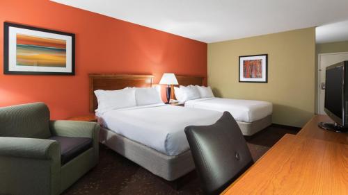 a hotel room with two beds and a tv at Holiday Inn Cincinnati-Riverfront by IHG in Covington
