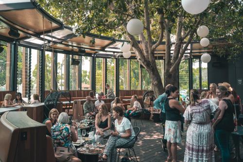 eine Gruppe von Menschen, die an Tischen in einem Restaurant sitzen in der Unterkunft Marion Hotel in Adelaide