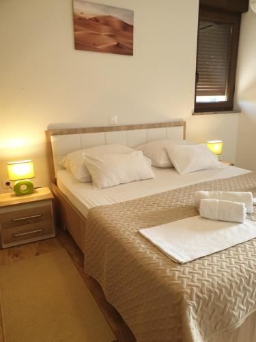 two beds in a bedroom with two lamps on a table at Villa Sara in Poreč