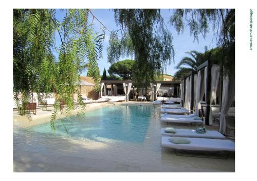 a swimming pool with chaise lounges in a resort at MUSE Saint Tropez - Small Luxury Hotels of the World in Saint-Tropez
